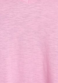 Světle růžový v-neck top vyrobený z jemné, strukturované tkaniny s mírnými barevnými variacemi. Má krátké rukávy a volný střih.
