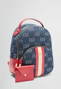 Zaino in denim con una forma curvata, dettagli rossi, hardware dorato e strisce bianche. Include un portacarte rosso abbinato.