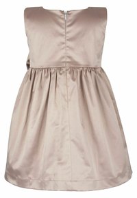 Beige ärmlös klänning i slät tyg, med rund halsringning, veckad kjol och en synlig dragkedja bak.