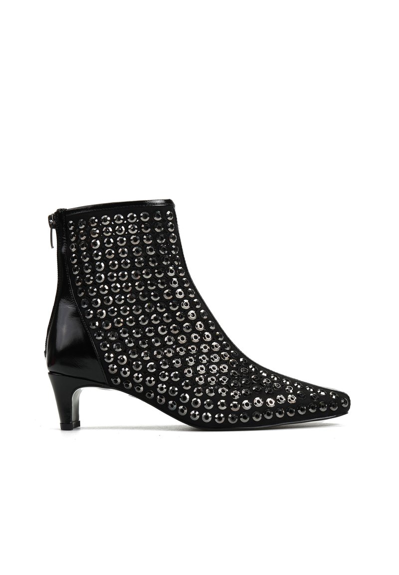 Czarny botek za kostkę z zaostrzonym noskiem, zdobiony metalowymi ćwiekami z przodu, z zamkiem błyskawicznym z tyłu oraz niskim, smukłym obcasem.