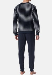 Navy striped sweatshirt with a round neckline and ribbed cuffs, paired with solid navy joggers, made from soft, smooth fabric.