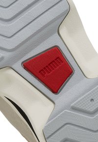 Schuhsohle mit einer strukturierten grauen Gummibasis, einem roten rechteckigen Akzent und einer glatten weißen Detailierung mit einem Wellenmuster.