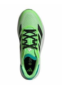 Zapatilla deportiva verde con parte superior de malla, franjas negras y cordones negros. Presenta una suela acolchada y acentos turquesa alrededor del talón.