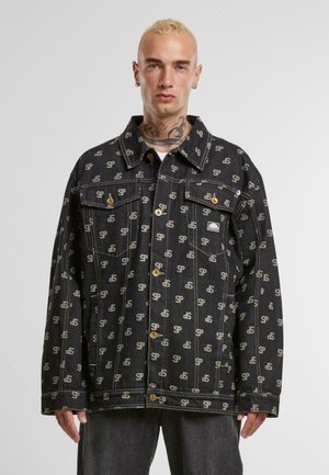 Schwarze Denimjacke mit einem wiederholten Logomuster in hellbeige, zwei Brusttaschen und goldfarbenen Knöpfen. Robustes Material und lässige Passform.