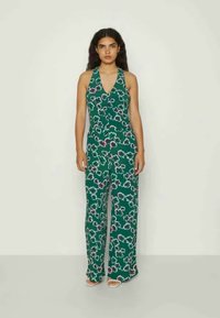Green floral jumpsuit with a halter neck, wide-leg design, and white flower patterns. Lightweight fabric, vibrant color, and relaxed fit.