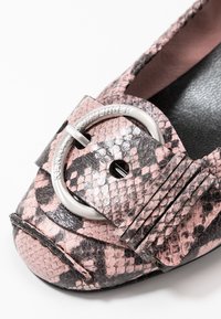 Zapato plano de estampado de serpiente en rosa y negro con una hebilla circular plateada y acentos plisados en la parte superior. Material texturizado y diseño de punta redonda.
