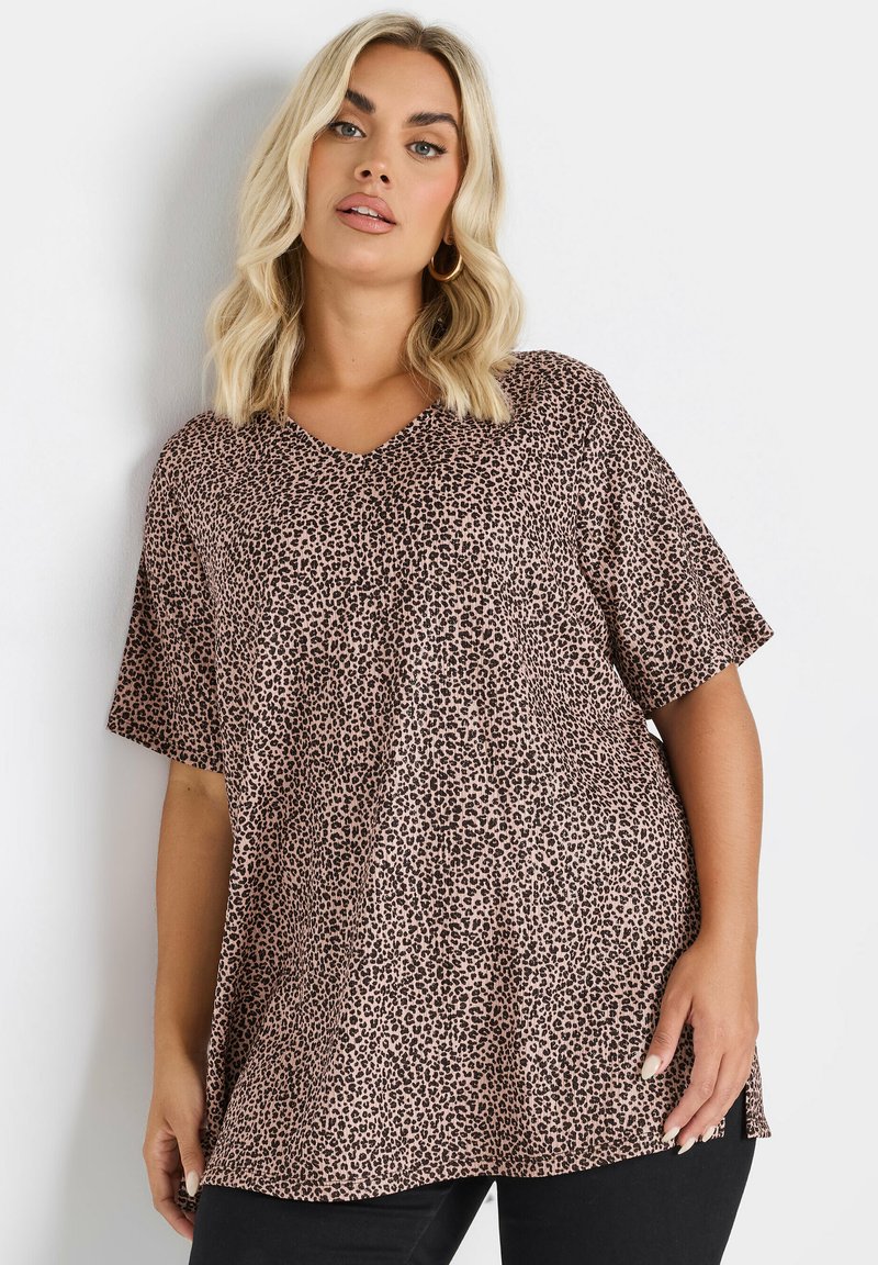 Oversized V-ringad topp i leopardmönster med korta ärmar, tillverkad av mjukt material i rosa och bruna nyanser, med sidoklyftor för extra komfort.