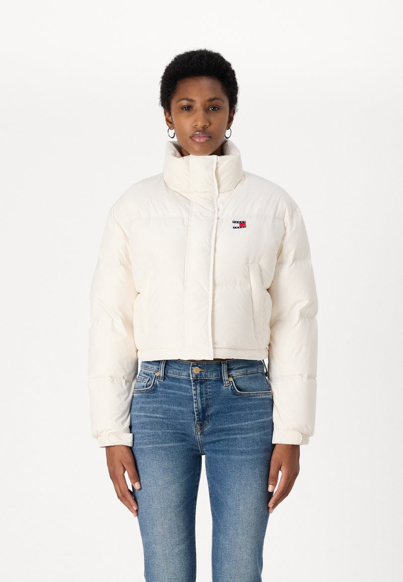 Giacca puffer cropped in bianco sporco, con colletto alto, design trapuntato e piccolo logo multicolore sul lato sinistro del petto.