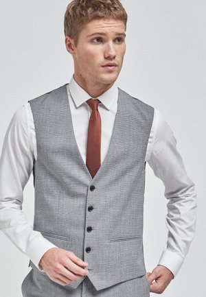Grau maßgeschneiderte Weste mit einem dezenten Muster, fünf schwarzen Knöpfen, Reverskragen und Taschen, kombiniert mit einem weißen Hemd und einer rostfarbenen Krawatte.