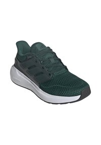 Zapatilla deportiva de color verde oscuro con parte superior de malla texturizada, tres franjas laterales y una suela blanca acolchada etiquetada como "CLOADFOAM."