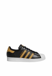 Black leather sneaker with yellow accents, featuring three stripes, a white rubber sole, and a classic shell toe design.