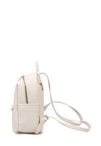 Zaino in pelle bianca con forma strutturata, dotato di una tasca frontale con zip e spallacci regolabili. Accenti in hardware di colore oro.