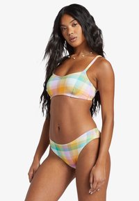 Bikini set s viacfarebným károvaným vzorom, ktorý obsahuje trojuholníkovú podprsenku s nastaviteľnými popruhmi a nízko vystužené spodky v textúrovanej tkanine.