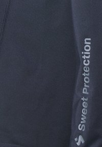 Sötétkék sportnadrág sima textúrával, amelyen a bal oldalon szürke színű "Sweet Protection" feliratú logó található.