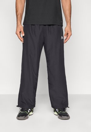 Pantalon de sport noir en tissu léger et lisse. Comprend une taille élastique, une coupe ample et des cordons de serrage aux chevilles. Logo discret sur le côté.