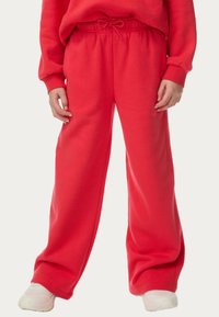 Røde, brede sweatpants med elastisk talje og snørredetalje. Lavet af blødt materiale, har en glat tekstur og en afslappet pasform.
