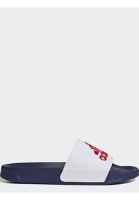 Sandalia deslizante blanca con una plantilla texturizada, suela azul marino y un logotipo rojo prominente en la correa. El material parece sintético y ligero.