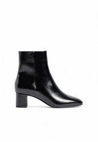 Črne gležnjarje iz sijoče usnje, z nazobčanim nosom in blokastim peto. Oblikovanje je elegantno z minimalnimi šivi in poudarki.