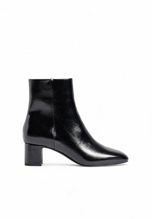 Black ankle boot made of glossy leather, featuring a pointed toe and a block heel. The design is sleek with minimal seams and accents.