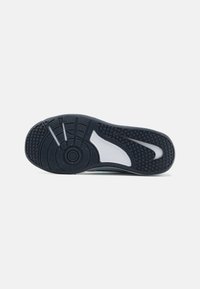 Shoe sole featuring a rubber material, black color with white accents, tread pattern, and a circular design near the heel for traction.