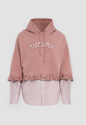 Hoodie rose cropped avec broderie « AVAVAV » et ourlet effiloché, superposé sur une chemise à rayures blanches et roses avec des boutons et des manches longues.