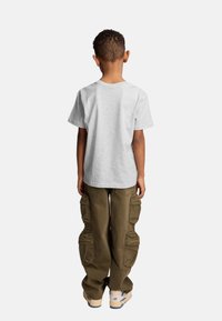 Szara krótka koszulka z okrągłym dekoltem, w połączeniu z oliwkowymi spodniami cargo z wieloma kieszeniami i luźnym krojem.