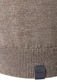 Bruine gebreide trui met een textuurstof, geribde onderkant en een klein zwart label met de merknaam.