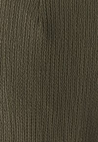 Dark olive green fabric with a textured, ribbed pattern and subtle horizontal lines, presenting a soft, woven appearance.