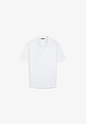 Polo shirt blanc à manches courtes avec une texture côtelée, présentant un col classique et une coupe légèrement décontractée. Aucune motif ni élément métallique visible.