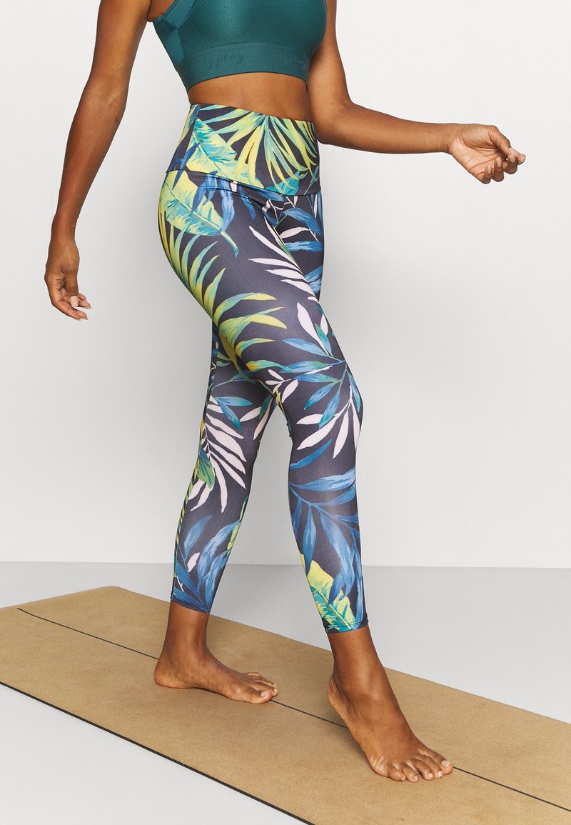 Leggings med en mörk bakgrund och livfulla tropiska lövmönster i nyanser av grönt, blått och rosa. Hög midja.