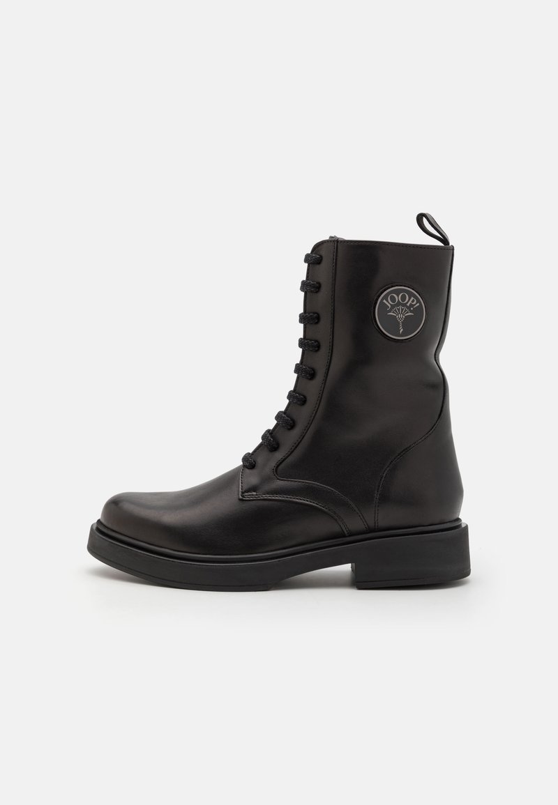 Bottine en cuir noir à lacets, bout arrondi et talon épais. Dispose d'un patch logo sur le côté et de lacets texturés.
