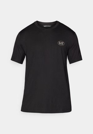 Camiseta negra de manga corta, hecha de una tela suave, con un cuello redondo y un pequeño logo blanco en el área del pecho izquierdo.