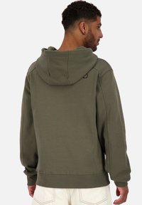 Olijfgroene pullover hoodie, met een grote capuchon, ribgebreide manchetten en zoom, een gladde textuur en een klein logo detail bij de nek.