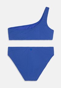 Blå bikinisett med en skuldertop med ribbet tekstur og matchende underdel. Inkluderer en liten knappdetalj på baksiden.