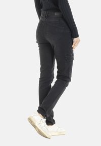 Pantalons cargo en denim noir à coupe slim, avec poches latérales, poches arrière et une légère élasticité pour le confort.
