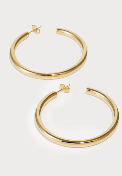 Pendientes de aro de oro con un acabado suave y brillante. Diseño circular, con cierre de presión para un uso seguro.