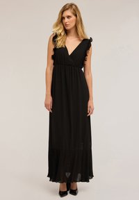 Schwarzes Maxikleid mit gefaltetem Saum, V-Ausschnitt und Rüscheärmeln. Hergestellt aus einem glatten Stoff, mit tailliertem Schnitt und fließendem Rock.