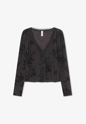 Melnā garām piedurknēm izšūtā ziedu krekliņa ar V veida izgriezumu, mežģīņu apdari un pogas aizdari, izgatavota no caurspīdīgas, teksturētas auduma.