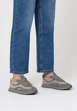 Sneakers grigi con un mix di materiali scamosciati e in rete, dotati di una suola testurizzata, design con lacci e sottili accenti grigio chiaro.
