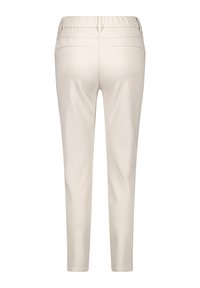 Beige stretch trousers with a smooth texture, featuring an elastic waistband and two back pockets, tapered fit towards the ankle.