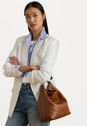 Brunt lædertaske med blød, slaskede design og kontrasterende hvid syning. Har en rund form og et kort håndtag.