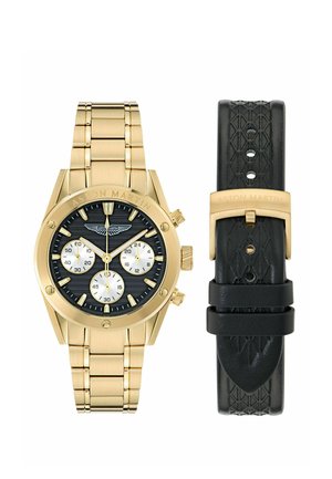 Goudkleurig Aston Martin chronograafhorloge met zwarte wijzerplaat, drie subwijzerplaten en een gebrande armband, gecombineerd met een zwarte leren band met patroon.