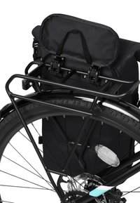 Čierny bicyklový nosič so snímateľným vrchnákom zabezpečeným klipsami, namontovaný na čiernom kovovom nosiči nad hrubou, štruktúrovanou pneumatikou.