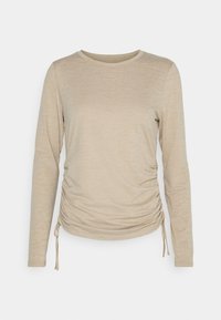 Light beige long-sleeve top with a crew neck, featuring gathered side detail and adjustable drawstrings at the hem. Soft fabric texture.