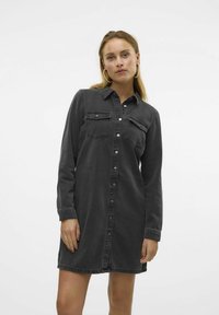 Mørkegrå denimskjortekjole med lange ermer, knappestolpe foran, to brystlommer og rette kanter. Glatt tekstur og uformelt design.