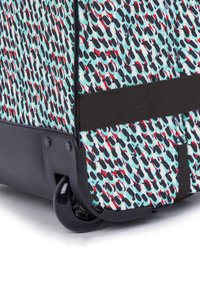Wheeled suitcase with a patterned fabric in turquoise, black, and red, featuring a sturdy black base and smooth rolling wheels.