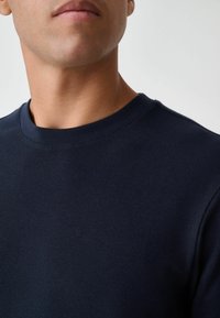 Marineblauw, geribbelde crewneck sweater met een gestructureerd oppervlak, smalle halslijn en korte mouwen, die een aansluitend ontwerp laat zien.