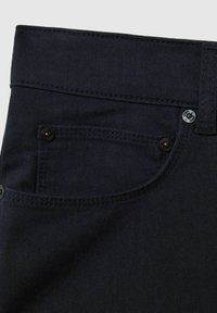 Donkerdenim jeans met een gladde textuur, een klassieke snit en koperen hardwareaccenten, waaronder een knoop en klinknageldetail op de zak.