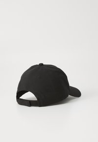 Svart bomullsbass cap med buet skjerm, justerbar stropp bak og en flat rund knapp på toppen. Enkel design uten mønstre.