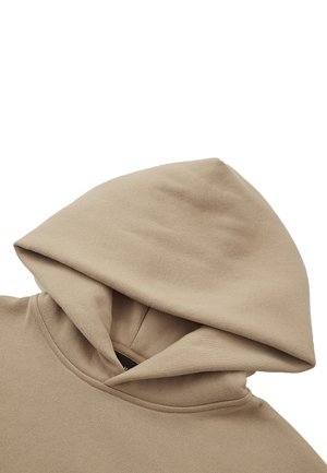 Sweat à capuche en coton beige avec une capuche structurée, présentant une texture douce et une ouverture de poche kangourou. Design simple sans motifs ni accents.